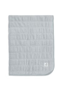 Couverture pour bébé en tissu côtelé gris clair avec un quilting horizontal et des coins arrondis, présentant une petite étiquette blanche avec le logo de la marque dans un des coins.