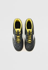 Pantofi sport negri cu textură matlasată, accente albe și șireturi galbene. Material neted și design de tip low-top.