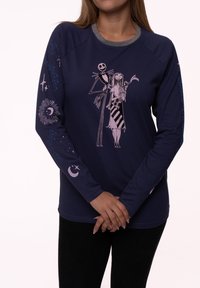 Navy long-sleeve shirt featuring a pink graphic of characters, with star and moon patterns on sleeves and a grey crew neckline.