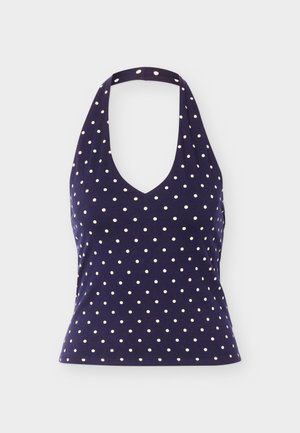 Haut dos nu bleu marine à pois blancs, encolure en V et taille cintrée, présenté sur un fond uni.