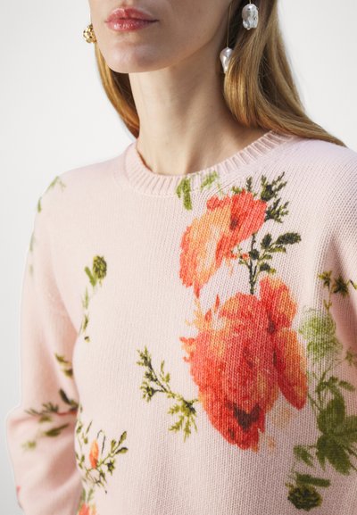 Light pink knitted sweater featuring large floral patterns in orange and green. Ribbed round neckline and soft texture.