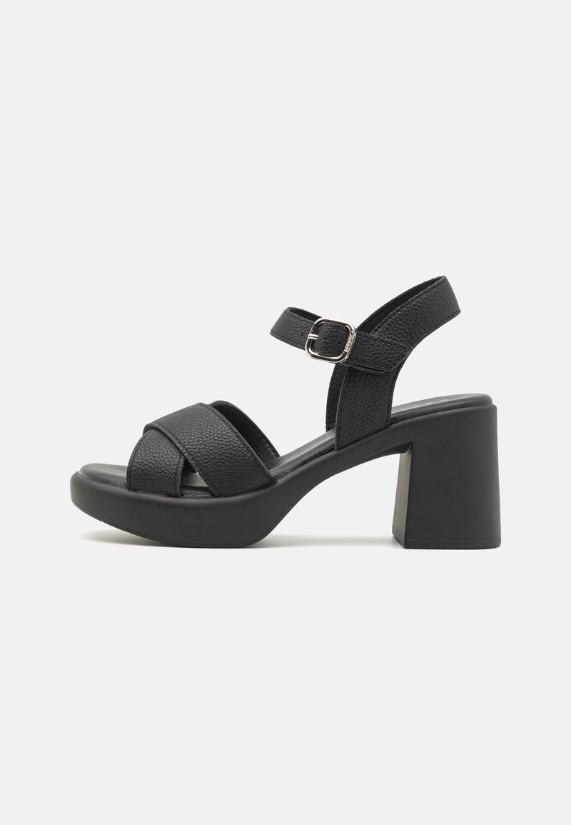 Svarte blokk-heel sandaler med teksturerte lærremmer. Har en spenne-lukking og er designet med en bred tååpning og solid hæl.