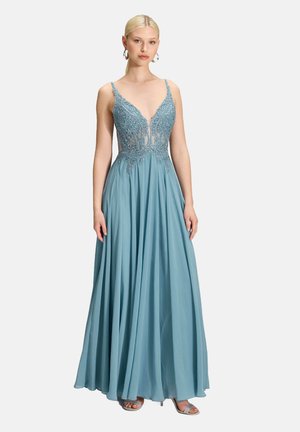 Long, A-line dress in light blue with a sheer, embellished bodice and deep V-neckline. Satin skirt flows gracefully, creating soft movement.