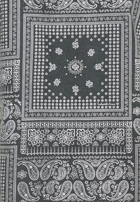 Tejido de bandana negra con intrincados patrones en blanco de paisley y flores, bordeado por diseños geométricos y puntos. Textura de algodón suave.