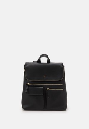 Musta nahkainen reppu, jossa on läpällinen kansi, kullanväriset metalliosat ja useita vetoketjullisia taskuja; sileä pinta ja minimalistiset design-yksityiskohdat.