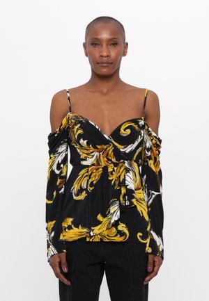 Black blouse with yellow and white floral pattern, off-shoulder design, wrap front, long sleeves, and tie accent at waist.