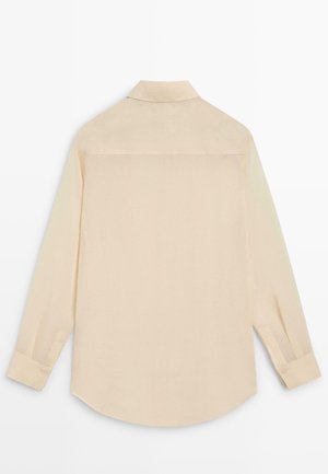 Beige long-sleeve buttoned shirt with a classic collar, shown from the back on a white background.