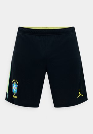 Μαύροι αθλητικοί σορτς με το έμβλημα της ομάδας ποδοσφαίρου της Βραζιλίας στο αριστερό πόδι και κίτρινο λογότυπο Jordan στο δεξί πόδι, με ορατή επένδυση ανοιχτού πράσινου στη μέση.