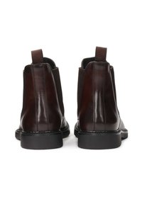 Braune Lederstiefel mit Knöchelhöhe, elastischen Seiteneinsätzen, strukturiertem Finish und einer robusten schwarzen Gummisohle. Doppelte Zugschlaufen für ein einfaches An-/Ausziehen.