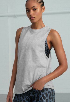 Szary bezrękawnik z okrągłym dekoltem i bocznymi wycięciami, odsłaniającymi niebiesko-czarny wzór w panterkę wewnętrzna warstwę. Miękka bawełniana tekstura.