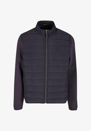 Tengerészkék pufikabát egyszínű testtel, bordázott ujjakkal, cipzáras záródással és egy kis logóval a mellrészen. Elöl steppelt textúrával rendelkezik.