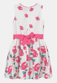 Robe blanche avec un motif floral rose et vert, design sans manches, et une ceinture rose nouée en nœud à la taille. Fermeture éclair à l'arrière.