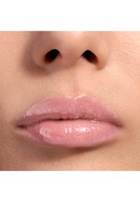 Labbra lucide e trasparenti con una leggera sfumatura rosa e un sottile brillantezza, che mostrano una texture liscia e lucida e contorni naturali.