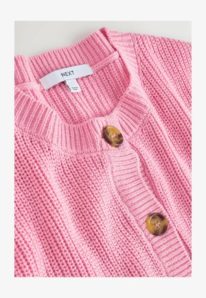 Lyserød strikket cardigan med ribbet struktur, rund halsudskæring og to store brune knapper foran. Etiketten siger "NEXT."