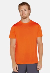Herre kortærmet t-shirt i klar orange, lavet af letvægtigt stof, med rund halsudskæring og en let struktureret overflade.