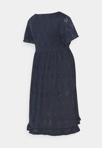 Mörkblå bomullsklänning med korta ärmar, med utskurna hål i ett mönster, rund halsringning och ett lager-på-lager, volangkant.