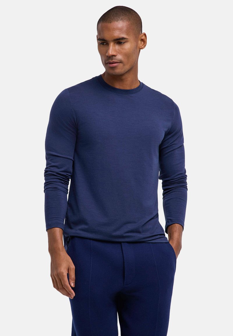 Navyblaues Langarmshirt mit Rundhalsausschnitt, glatte Textur, figurbetontes Design, kombiniert mit passenden marineblauen Hosen, minimale Details, lässiger Stil.