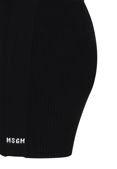 Sort ribbet striknederdel med en tætsiddende silhuet, der har et horisontalt design og en hvid "MSGM" logo ved kanten.