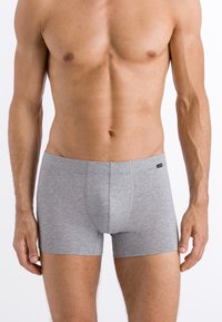 Grå boxertrosor gjorda av ett mjukt tyg, med en slät textur, elastisk midjeband och en formad framficka design.