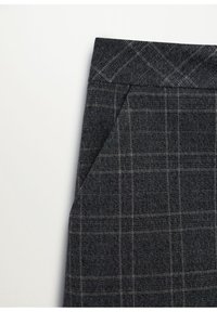 Tissu gris foncé avec un motif à carreaux gris clair subtil, montrant un coin plié et une partie de la ceinture.