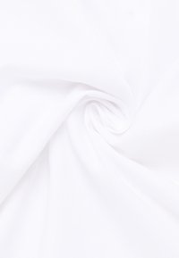 Weißer Stoff mit einer strukturierten Webart, spiralartig angeordnet. Die Oberfläche wirkt glatt und atmungsaktiv und hebt die helle Farbe hervor.