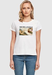 Hvid bomulds t-shirt med et centralt grafisk motiv af Michelangelos kunstværk, med fed tekst "MICHELANGELO" over billedet. Korte ærmer.
