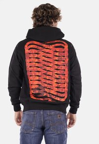 Hoodie nero con una grande grafica rossa e arancione sul retro, caratterizzata da forme astratte e linee audaci. Completato con un ampio cappuccio.