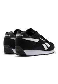 Zapatillas negras que combinan ante y malla, con acentos en blanco y un diseño de rayas distintivo. Incluyen una suela de goma texturizada.