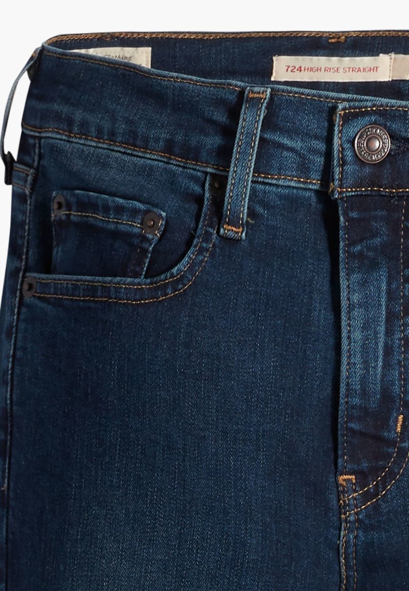Jean droit taille haute en denim bleu foncé, avec une poche avant, des coutures contrastées et un bouton en métal pour la fermeture de la taille.