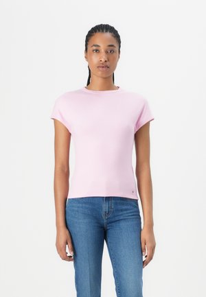Tricou scurt cu mânecă scurtă, de culoare roz pal, cu guler rotund, formă ajustată și un mic accent cu logo aproape de tiv. Asortat cu blugi blue.