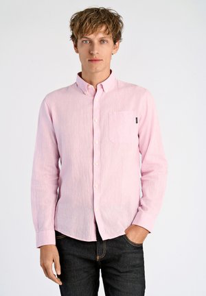 Helles rosa Langarm-Hemd mit Knopfverschluss und Tasche, aus strukturiertem Stoff mit Kragen, kombiniert mit dunklen Jeans.