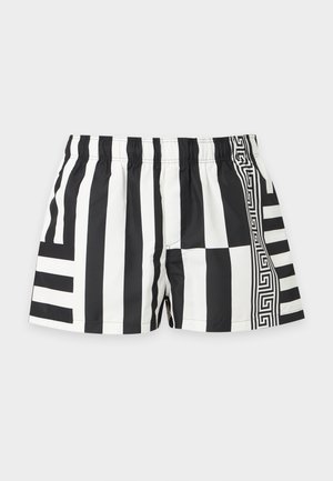 Short homme noir et blanc avec de larges rayures verticales, un motif clé grec à droite et une ceinture élastique. Design géométrique.
