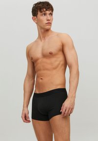 Schwarze Baumwollboxershorts mit einem bequemen Bund, ausgestattet mit einem figurschmeichelnden Design und einer glatten, einfarbigen Textur.