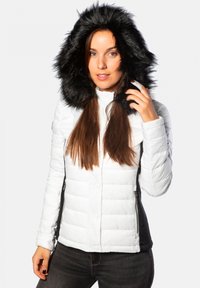 Doudoune blanche avec capuche en fausse fourrure noire, dotée d'une poche zippée sur le côté et d'un design matelassé horizontal. Tissu texturé avec une finition lisse.