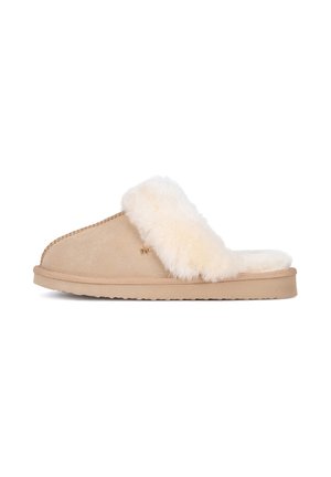 Beige slip-on tøfler med tyk, fluffy hvid pelsforing og flad sål, vist fra siden på hvid baggrund.