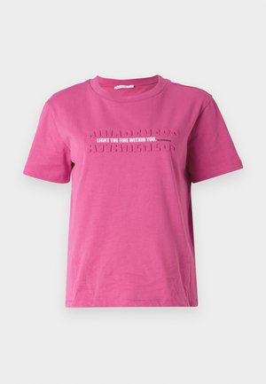 Rozā kokvilnas T-krekls ar īsām piedurknēm, ar izcilu tekstu "Iededz uguni sevī" un atkārtojošu "APZIŅA" rakstu.