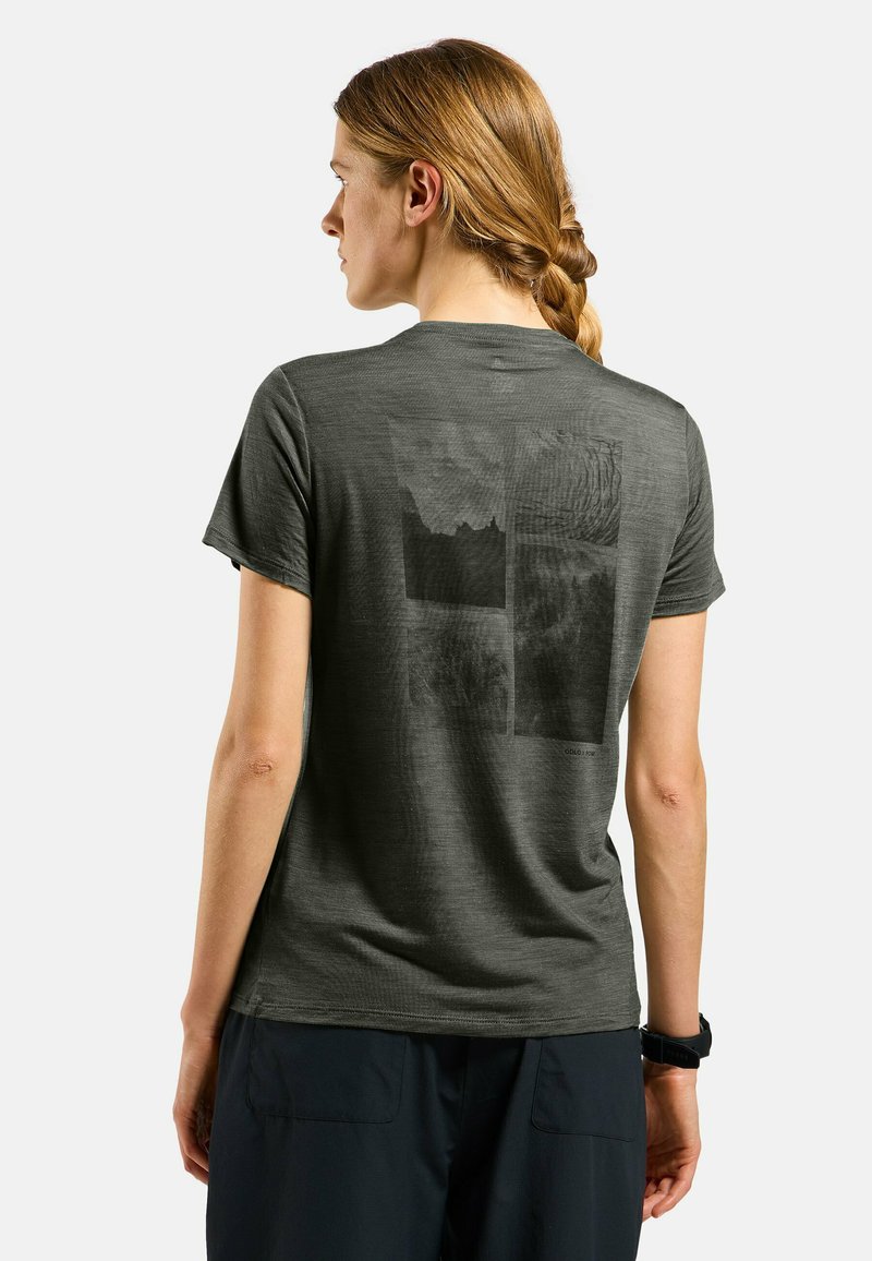 T-shirt à manches courtes gris foncé avec une finition texturée et un imprimé graphique au dos mettant en avant des éléments de paysage abstrait.