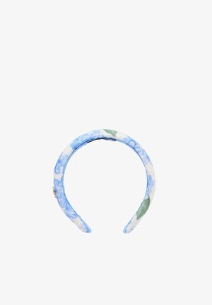 Bandeau en tissu rembourré avec motif floral bleu et feuilles vertes sur fond blanc, comportant un petit détail décoratif doré sur un côté.