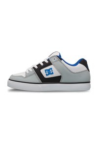 Zapatillas DC con un diseño en gris y negro con acentos blancos, parte superior texturizada, detalles en azul y un logo negro en el lateral.