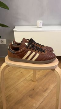 Smeđe kožne tenisice s teksturiranim završetkom, s tri bež pruge, crnim vezicama i akcentom od brušene kože na peti. Model "Samba."