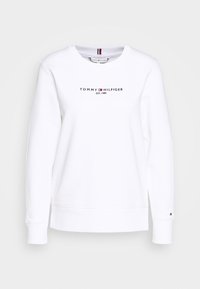 Sudadera blanca con cuello redondo, con el logo "TOMMY HILFIGER" en negro y rojo. Puños y dobladillo acanalados, textura de tela suave.