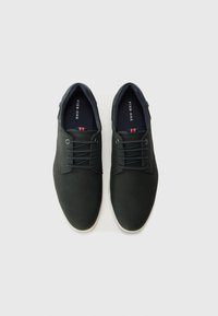 Black leather shoes with round toe, contrasting white sole, and flat laces. Features the brand "Pier One" inside and a color accent on the heel.