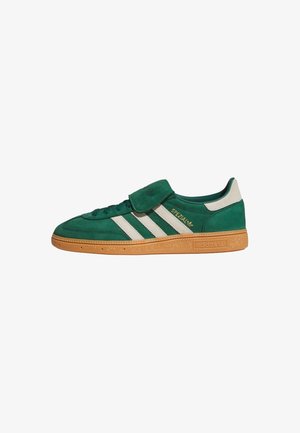 Baskets Adidas Spezial vertes avec bandes blanches, semelle en gomme et design à lacets avec une bride Velcro sur le dessus.