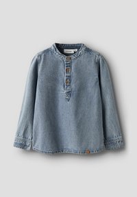 Gaiši zila džinsa garām piedurknēm krekls ar apaļu kakla izgriezumu, trim koka pogām priekšpusē un akcentētu šuvi apakšmalā un piedurknēs.