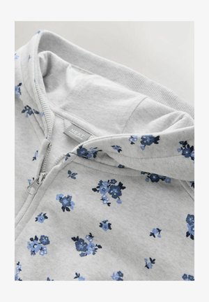 Hall halliga tõmblukuga kapuutsiga jakk, millel on sinistes toonides lillemuster, pehme tekstuur ja kengurutasku disain. Sisaldab nööriga kapuutsi.