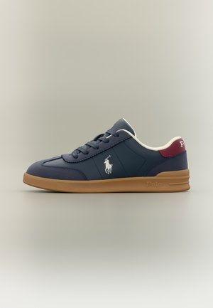 Marineblå Polo sneaker med gummisål, hvidt logo på siden, bordeaux hælstrop og hvidt inderfoer, vist i sideprofil.