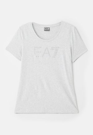 Világosszürke, puha anyagú póló, kerek nyakkivágással és rövid ujjakkal. Az elején egy diszkrét EA7 logó látható strasszkövekből.