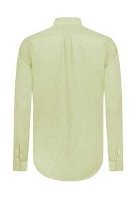 Camisa de manga larga hecha de tela verde claro. Presenta un cuello con botones, un pliegue en la espalda y puños abotonados. Textura suave, brillo sutil.