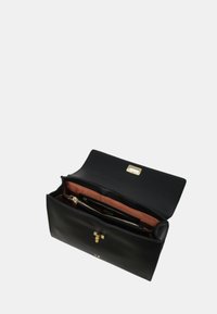 Borsa a tracolla in pelle nera con chiusura dorata. L'interno è foderato in tessuto pesco, con una tasca con zip e diversi slot per carte.