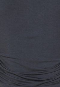 Tmavě námořnický fitted top vyrobený z elastické tkaniny, který má na bocích nařasené detaily a jemnou strukturu s mírným leskem.